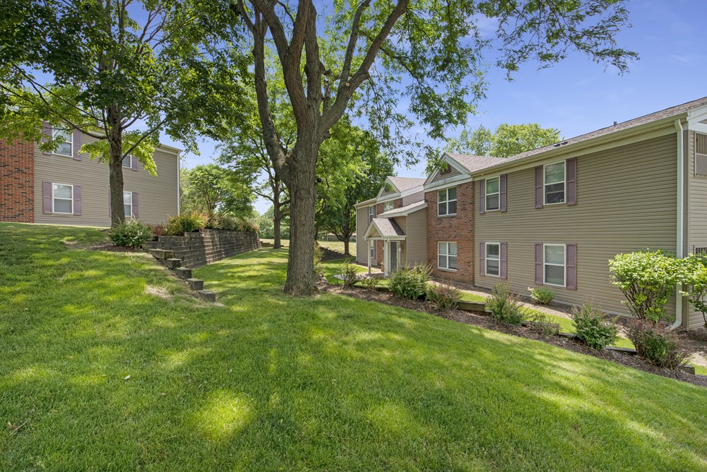 exterior view of multiple apartment buildings with grass and trees