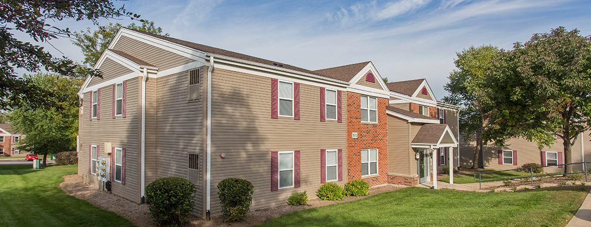 a view of a building with a lawn and trees