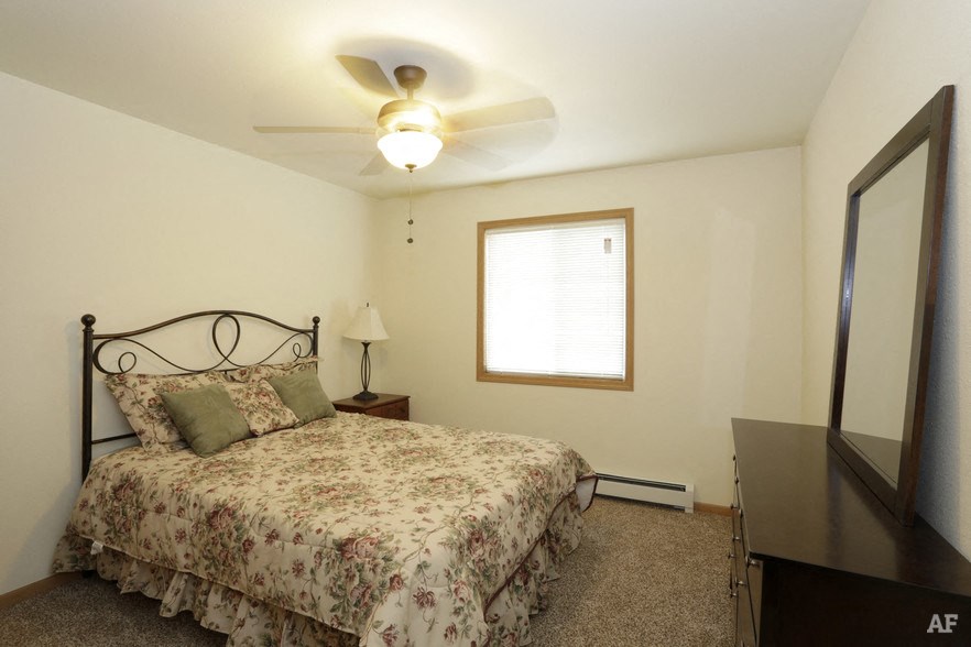 a bedroom with a bed and a ceiling fan