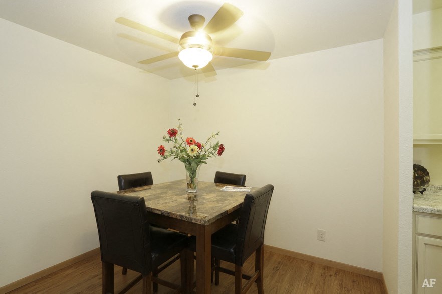 a dining room with a table and chairs and a ceiling fan