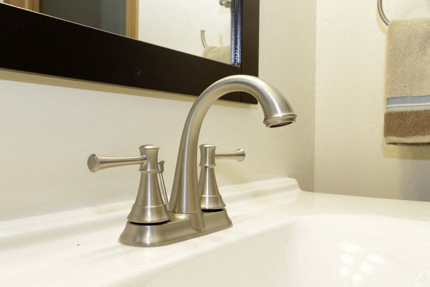 a bathroom sink with a chrome faucet and a mirror