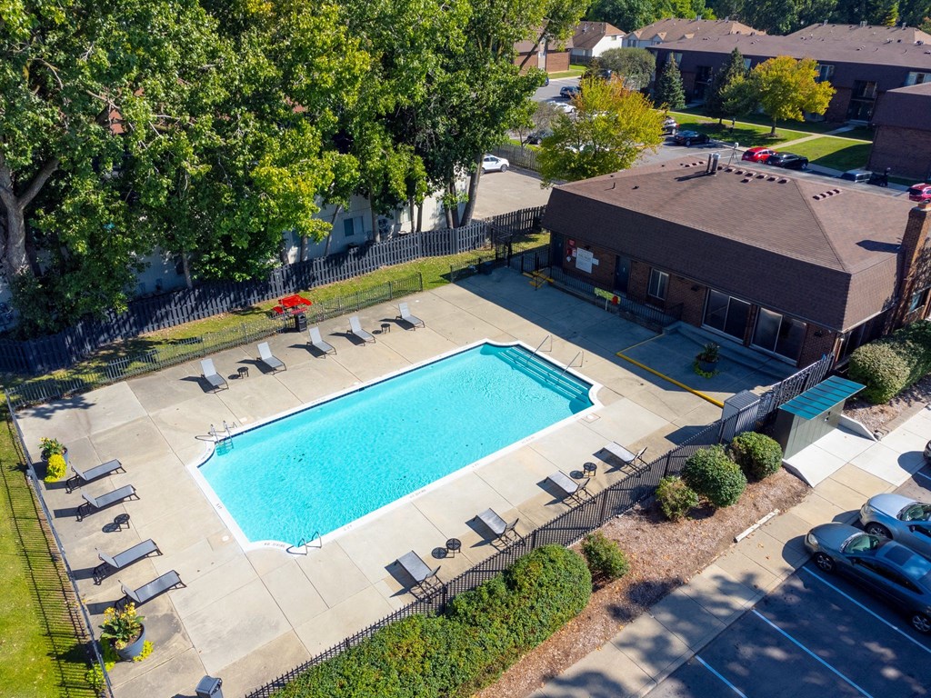 Large open area with heated pool and lounge chairs at Knottingham Apartments in Clinton Township, MI