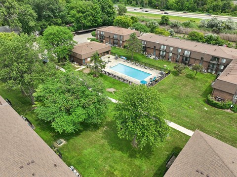 A bird's eye view of apartment complex with a pool.