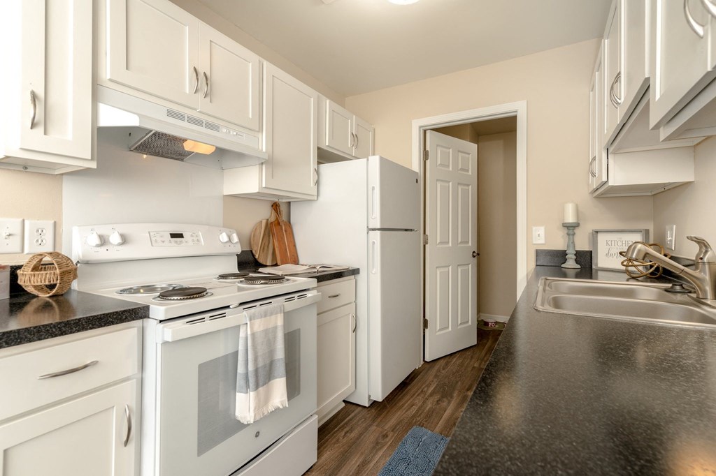 Kitchen with White Cabinets and Appliances at Three Oaks Apartments in Troy, MI