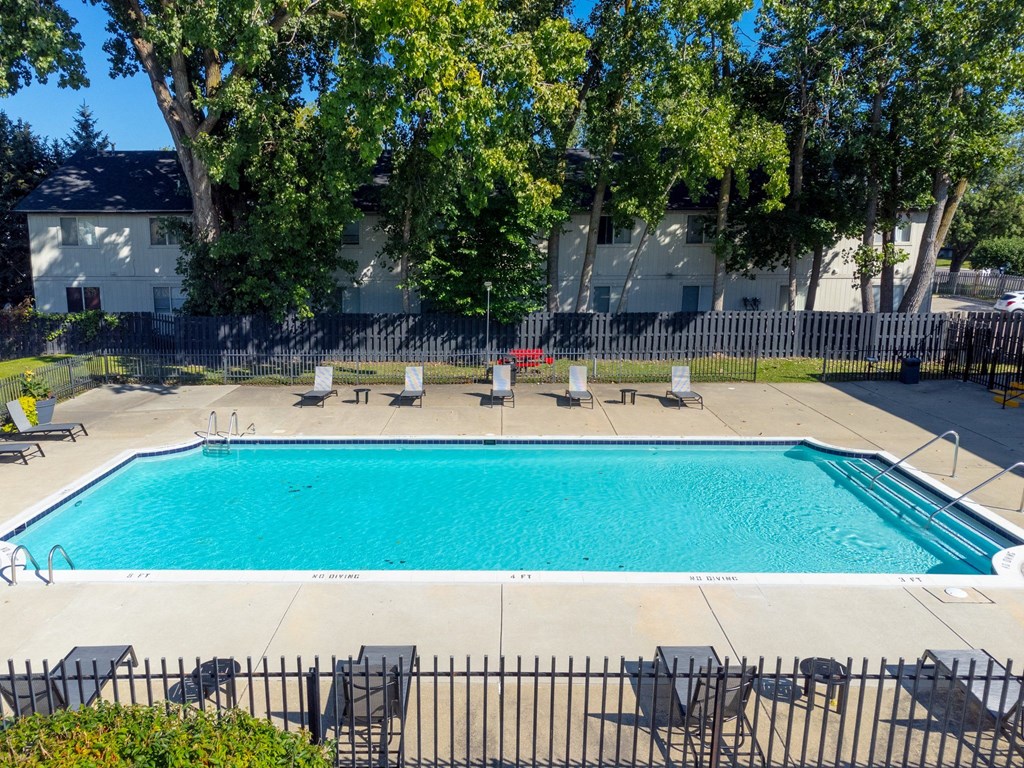 Heated Pool patio with lounge chairs at Knottingham Apartments in Clinton Township, MI
