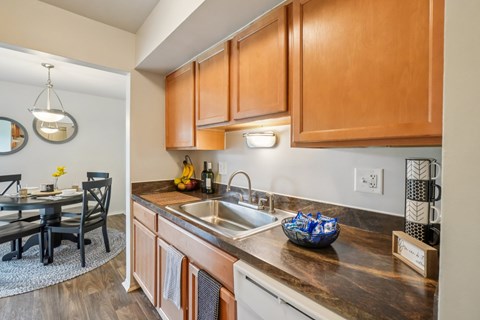 A kitchen with wooden cabinets and a black table.