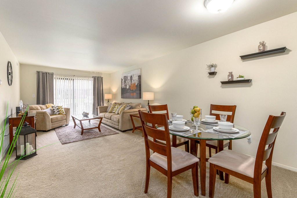 a living room and dining room with a table and chairs