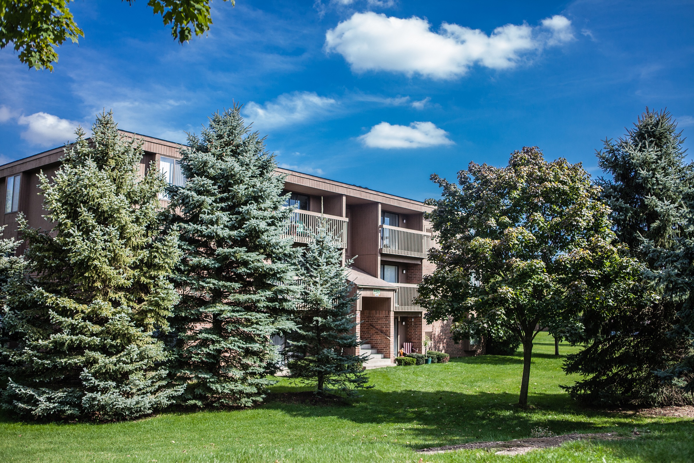 Exterior building with trees in courtyard at Dover Hills Apartments in Kalamazoo, MI
