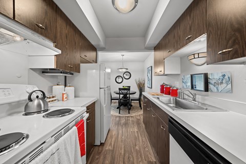 A modern kitchen with a white stove top oven and a white dishwasher.