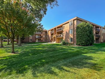 A large grassy area in front of apartment buildings.