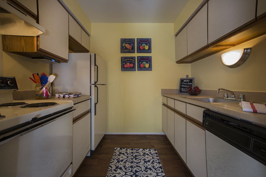 Plenty of cabinet space for all your kitchen needs Kitchen with white cabinetry at Westwood Village Apartments in Westland, MI