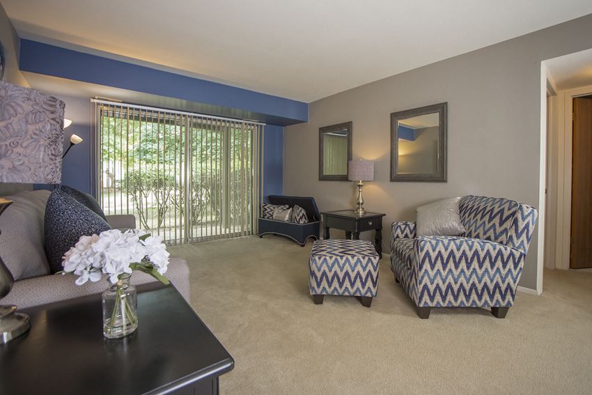 Exceptional value and phenomenal views Spacious living room with large sliding glass door and phenomenal view at Westwood Village Apartments in Michigan