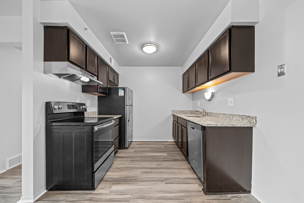Upgraded Kitchen with stainless steel appliances and granite countertops at Westwood Village Apartments in Westland, MI