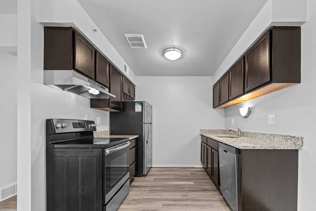 Upgraded Kitchen with stainless steel appliances and granite countertops at Westwood Village Apartments in Westland, MI