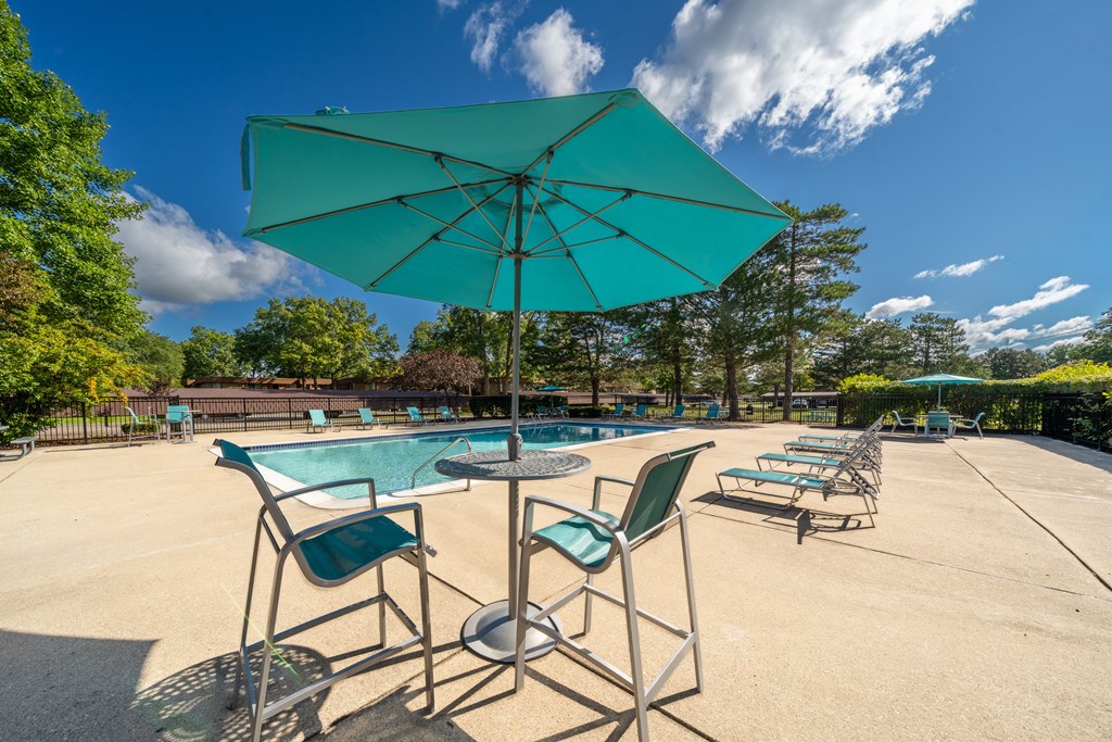 Heated pool equipped with comfy lounge chairs at Westwood Village Apartments in Westland, MI