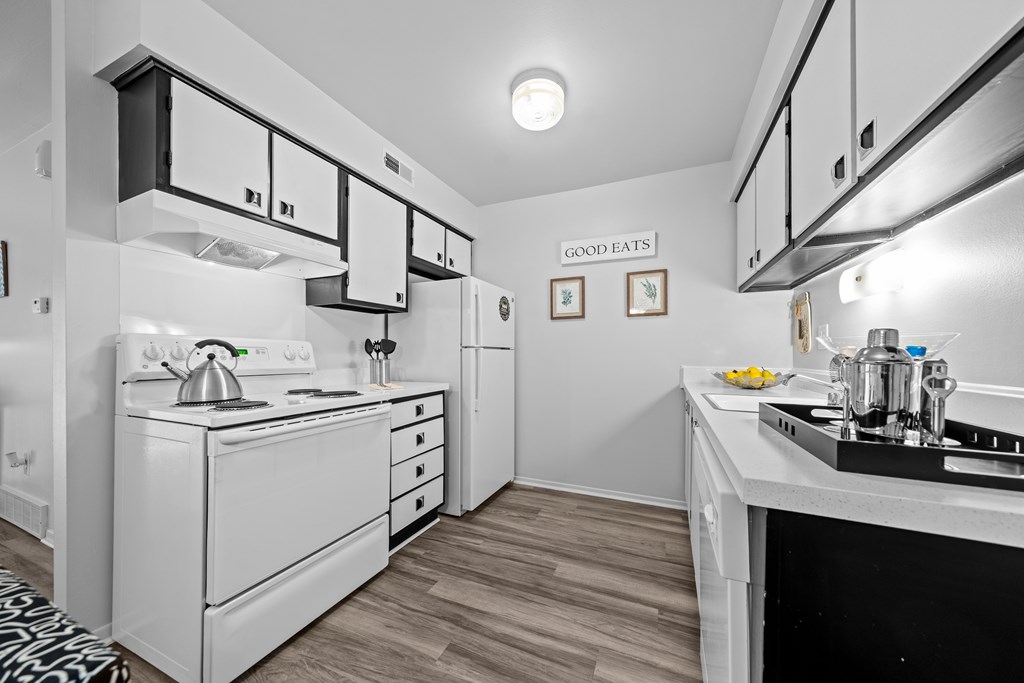 A modern kitchen with black and white cabinets at Westwood Village Apartments in Westland