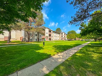 Expansive green space with picnic area at Woodland Villa Apartments in Westland, MI.