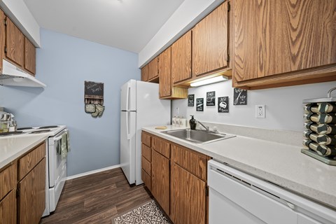 A kitchen with wooden cabinets and white appliances.
