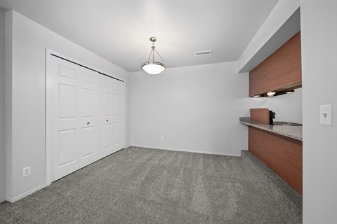 A room with a white door and a carpeted floor.