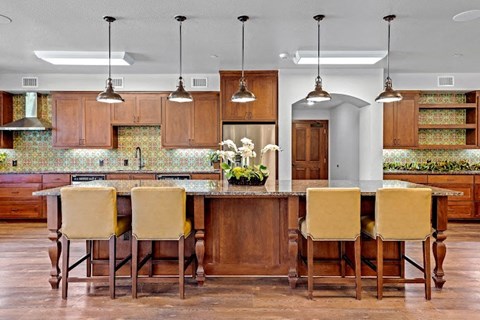 a kitchen with a large island with chairs