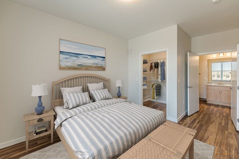 A bedroom with a large bed and a painting on the wall.