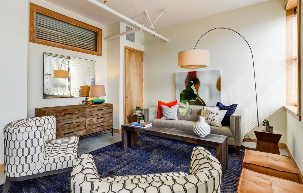 Living room with comfortable chair at Arcade Artist Apartments, Missouri