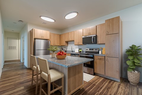 A kitchen with wooden cabinets and a granite countertop.