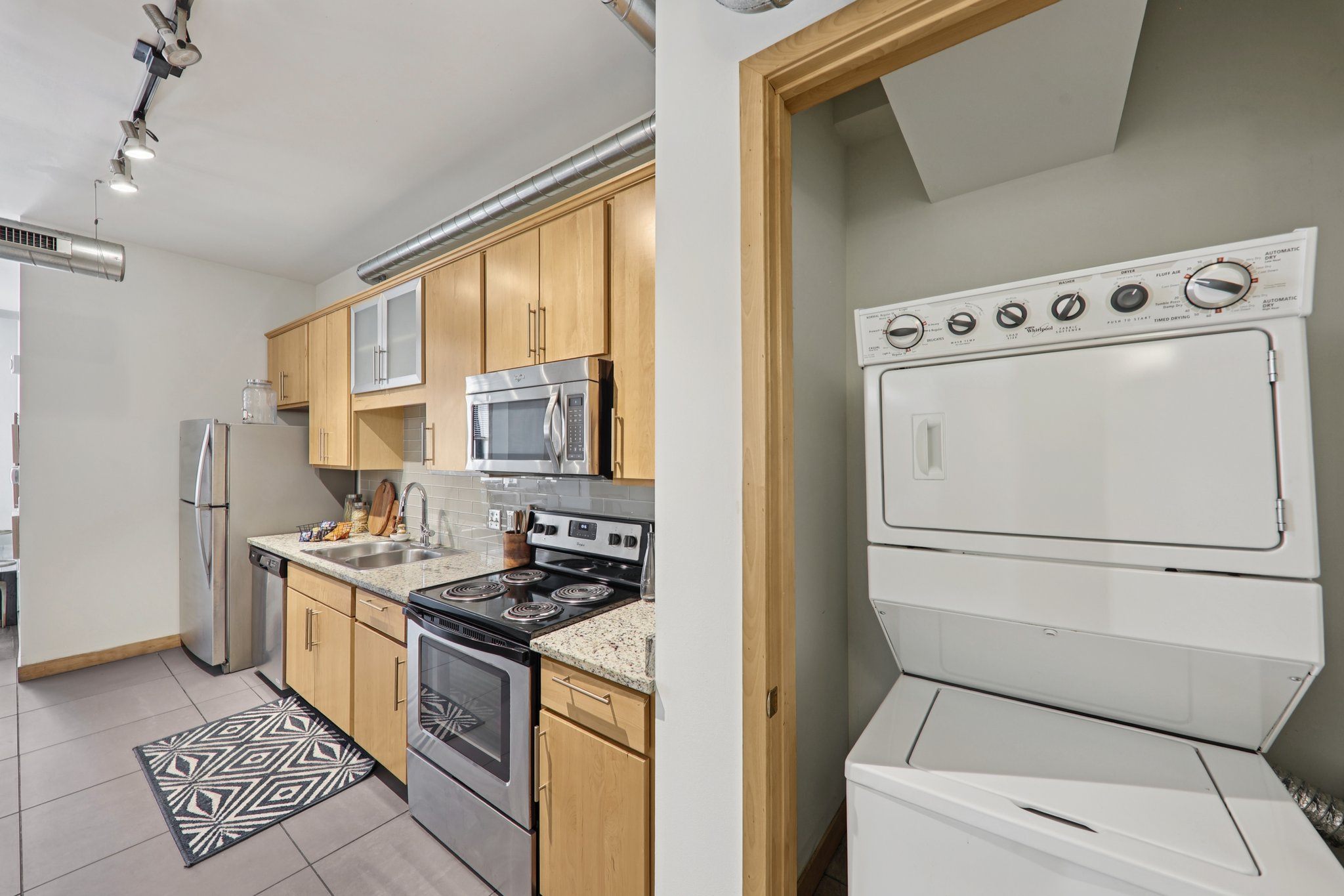 A modern kitchen with wooden cabinets and stainless steel appliances.