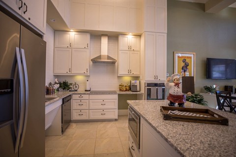 a kitchen with white cabinets and granite counter tops