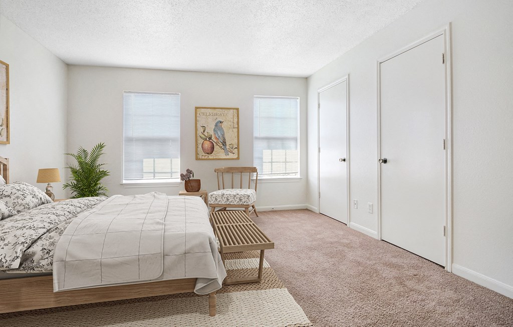 a bedroom with a bed and a chair and a closet at The Bluffs at Cherry Hills, Omaha, 68122