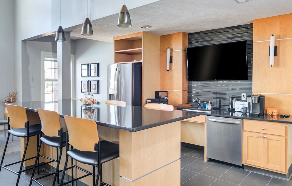 a kitchen with a large island with bar stools and a tv in a house at The Bluffs at Cherry Hills, Omaha