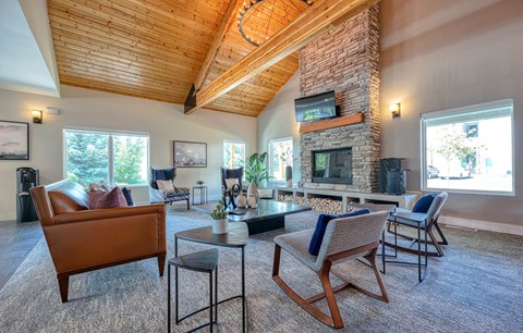 a living room with a large stone fireplace and furniture