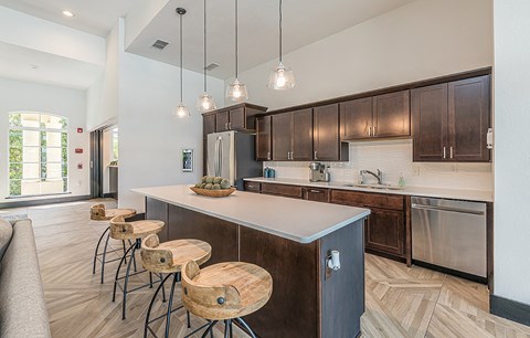 a kitchen with stools in front of a counter top