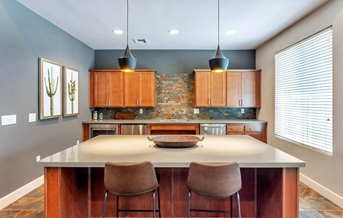 a kitchen with a large island with three chairs
