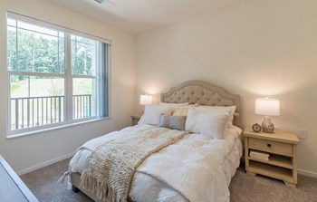 Bedroom with cozy bedat Covington Crossings 55+ Senior Living, Covington, GA, 30014 - Photo Gallery 44