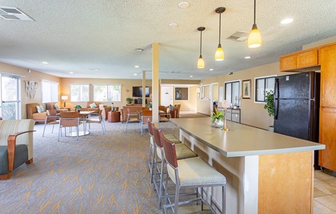 a large kitchen with a counter top and chairs