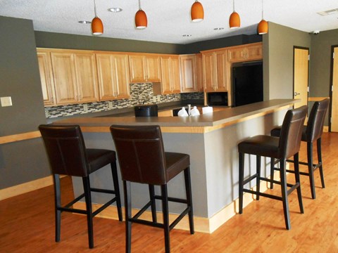 a kitchen with a counter and chairs