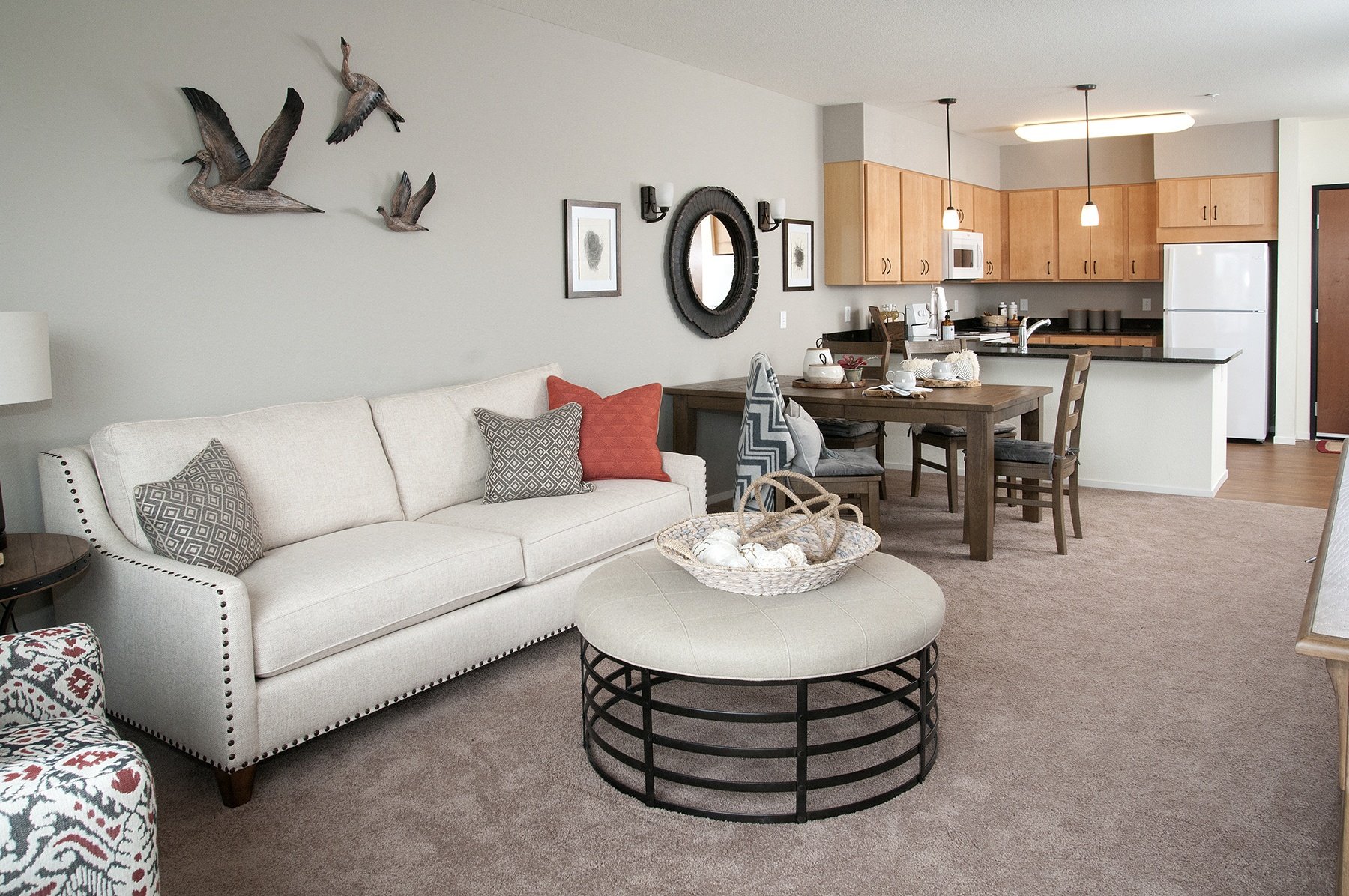 a living room with a couch and a table in front of a kitchen