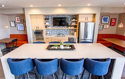 a kitchen with a large table and blue chairs