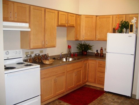 a kitchen with white appliances and wooden cabinets