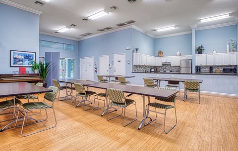 a conference room with tables and chairs and a kitchen