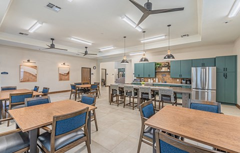 a large dining room with tables and chairs and a kitchen