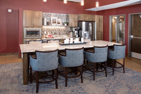 a large kitchen with a bar with blue chairs