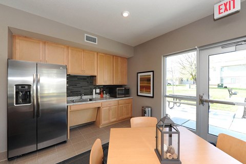 a kitchen with a table and a stainless steel refrigerator