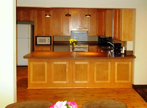 a kitchen with wooden cabinets and a wooden floor