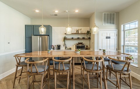 a kitchen with a large wooden table and chairs