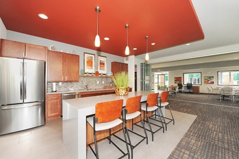 a kitchen with a long counter and chairs