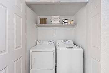 a white washer and dryer in a white laundry room