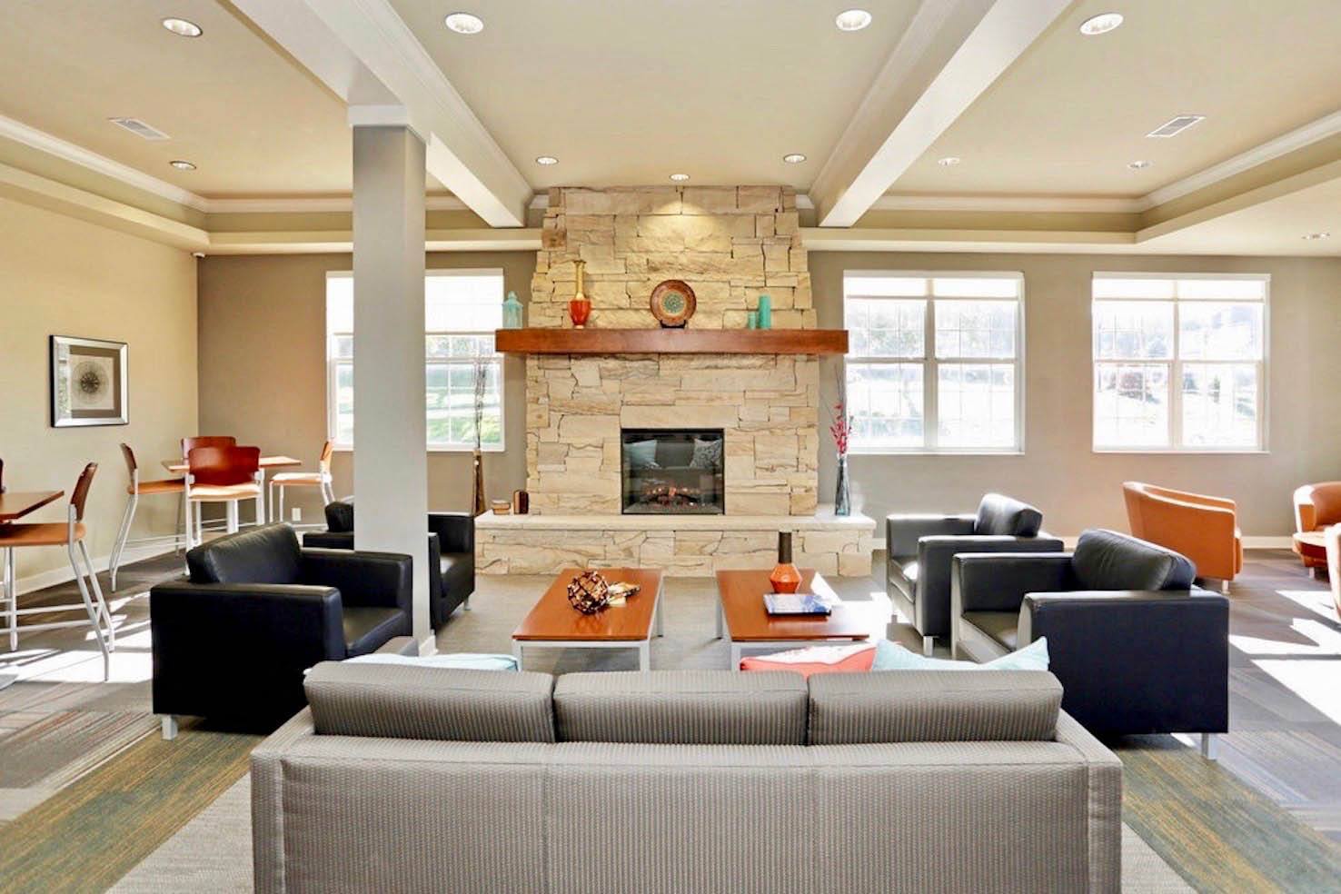 a large living room with a stone fireplace and couches