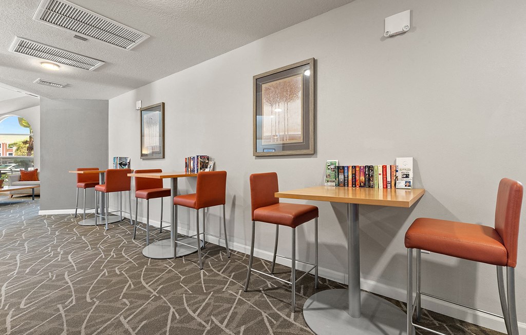 a community room with tables and chairs and a large window